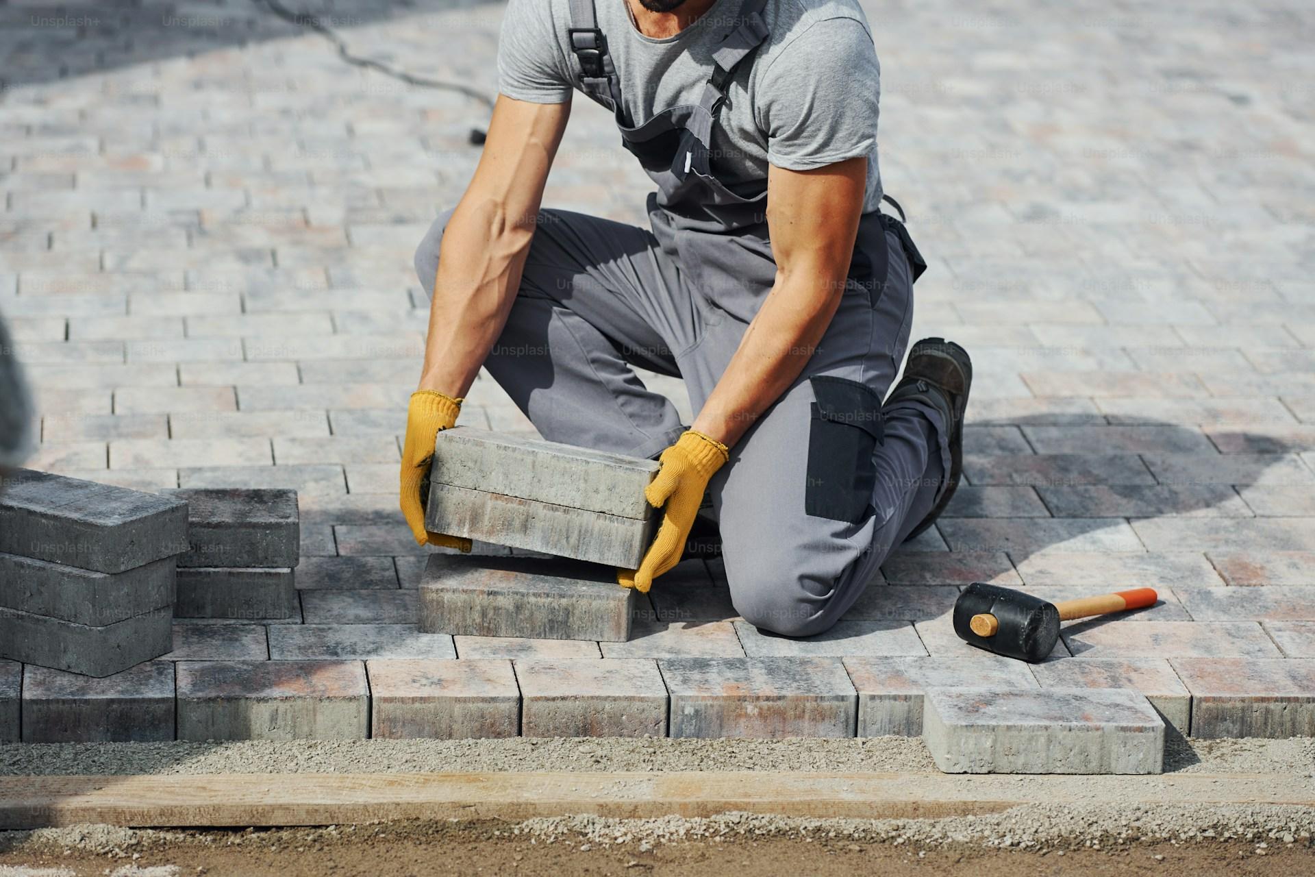 Paving contractor laying pavers on site — Central Florida