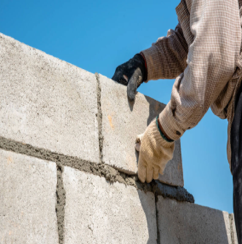 Worker laying CMU block wall