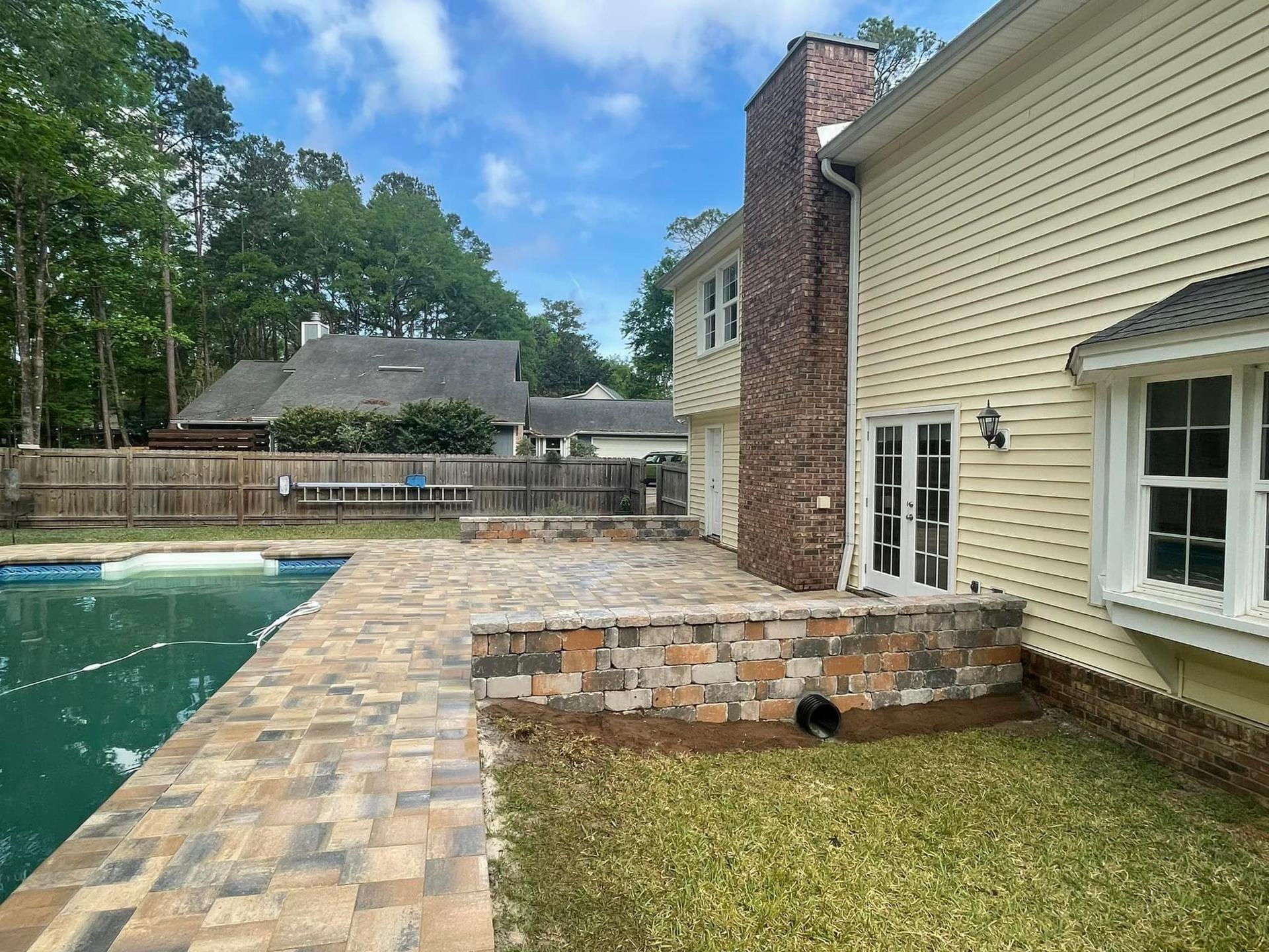 Raised paver patio and retaining structure on a sloped lot in Clermont, FL